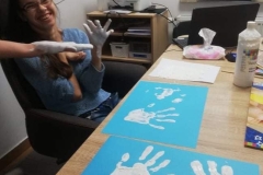 Uczestniczka maluje dłońmi