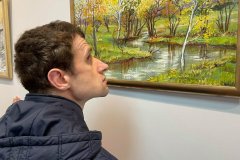 Uczestnik ogląda wystawę  malarska Stefanii Wójcik w Janowskim Ośrodku Kultury