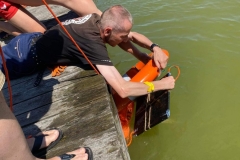 Wyciąganie boi z wody przez uczestnika ŚDS i ratownika WOPR na przystani w Janowie Lub.