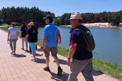 Uczestnicy ŚDS wraz z opiekunami i ratownikiem WOPR nr 10 z Janowa Lub spacerują po Zalewie Janowskim.