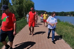 Uczestnicy ŚDS wraz z opiekunami i ratownikiem WOPR nr 10 z Janowa Lub spacerują po Zalewie Janowskim.