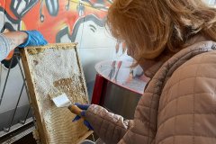 Uczestnicy ŚDS podczas warsztatów pszczelarskich uczą się w jaki sposób wydobywa się miód.