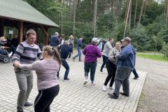Uczestnicy ŚDS wspólnie tańczą pod wiatą w Nadleśnictwie
