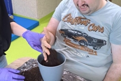 Uczestnicy podczas zajęć terapeutycznych pracuje z ziemią 