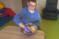 Uczestnicy podczas zajęć terapeutycznych pracują w piasku kinetycznym