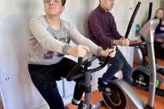 Uczestnicy ŚDS ćwiczą na sali usprawniania ruchowego