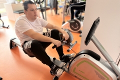 Uczestnicy ŚDS ćwiczą na sali usprawniania ruchowego