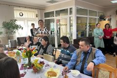 Uczestnicy podczas Spotkania Wielkanocnego, Dyrektor ŚDS częstuje babką