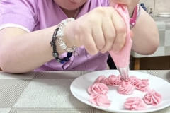 Uczestnicy ŚDS podczas warsztatów cukierniczych uczą się metody strojenia tortów