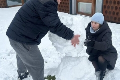 Uczestnicy ŚDS na świeżym powietrzu rzucają się śnieżkami i lepią bałwana