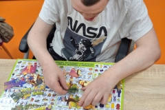 Uczestnicy ŚDS podczas treningu umiejętności spędzania czasu wolnego ukadają puzzle