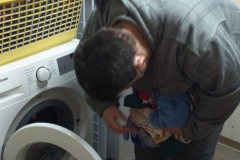 Uczestnik wkłada brudne pranie do pralki