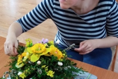 Uczestniczka podczas warsztatów florystycznych wykonuje stroik