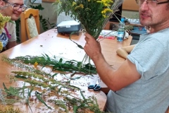 Uczestnicy podczas warsztatów florystycznych wykonują prace z żywymi trawami