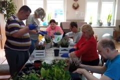 Uczestnicy podczas warsztatów florystycznych wykonują  prace z wrzosu
