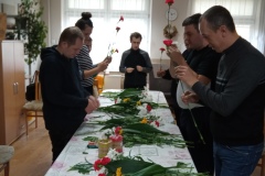 Uczestnicy tworzą bukiet z żywych kwiatów