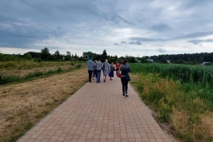Uczestnicy ŚDS idą chodnikiem wokół zalewu Janowskiego.