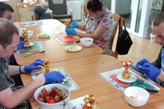 Uczestnicy ŚDS uczestniczą w warsztatach z carvingu. Uczą się tworzenia dekoracji i rzeźb z warzyw i owoców.