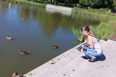 Uczestniczka ŚDS karmi kaczki w parku Misztalec