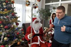 Uczestnicy otrzymują prezent od Świętego Mikołaja w ŚDS