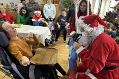 Uczestnicy otrzymują prezent od Świętego Mikołaja w ŚDS