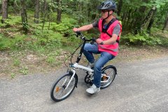 Uczestnik ŚDS jedzie rowerem po lesie.
