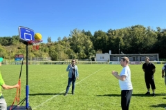 Uczestnicy ŚDS rzucają do kosza na stadionie miejskim w Bychawie