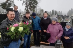 Grupa uczestników ŚDS z wizytą na cmentarzu, składają wiązankę na grobie byłej uczestniczki
