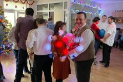 Uczestnicy ŚDS Janów Lubelski i ŚDS Prawno podczas wspólnej zabawy choinkowej bawią się i tańczą.