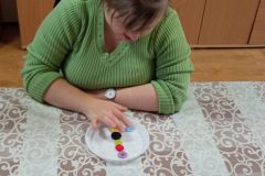 Uczestnicy ŚDS segregują guziki, utrwalają znajomość kolorów, figur