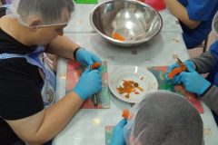 Trening kulinarny uczestników ŚDS, obieranie warzyw na sałatkę